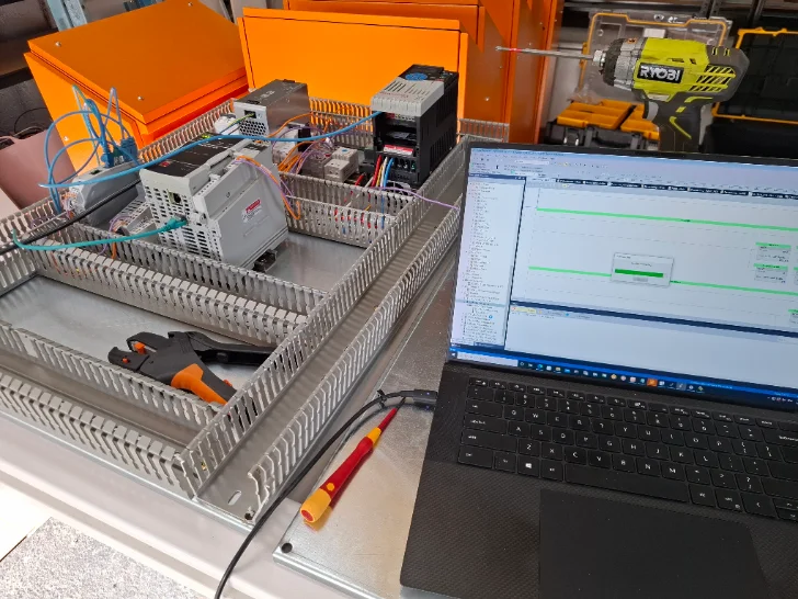 Allen-Bradley CompactLogix on the bench, ladder code online in Studio 5000 alongside
