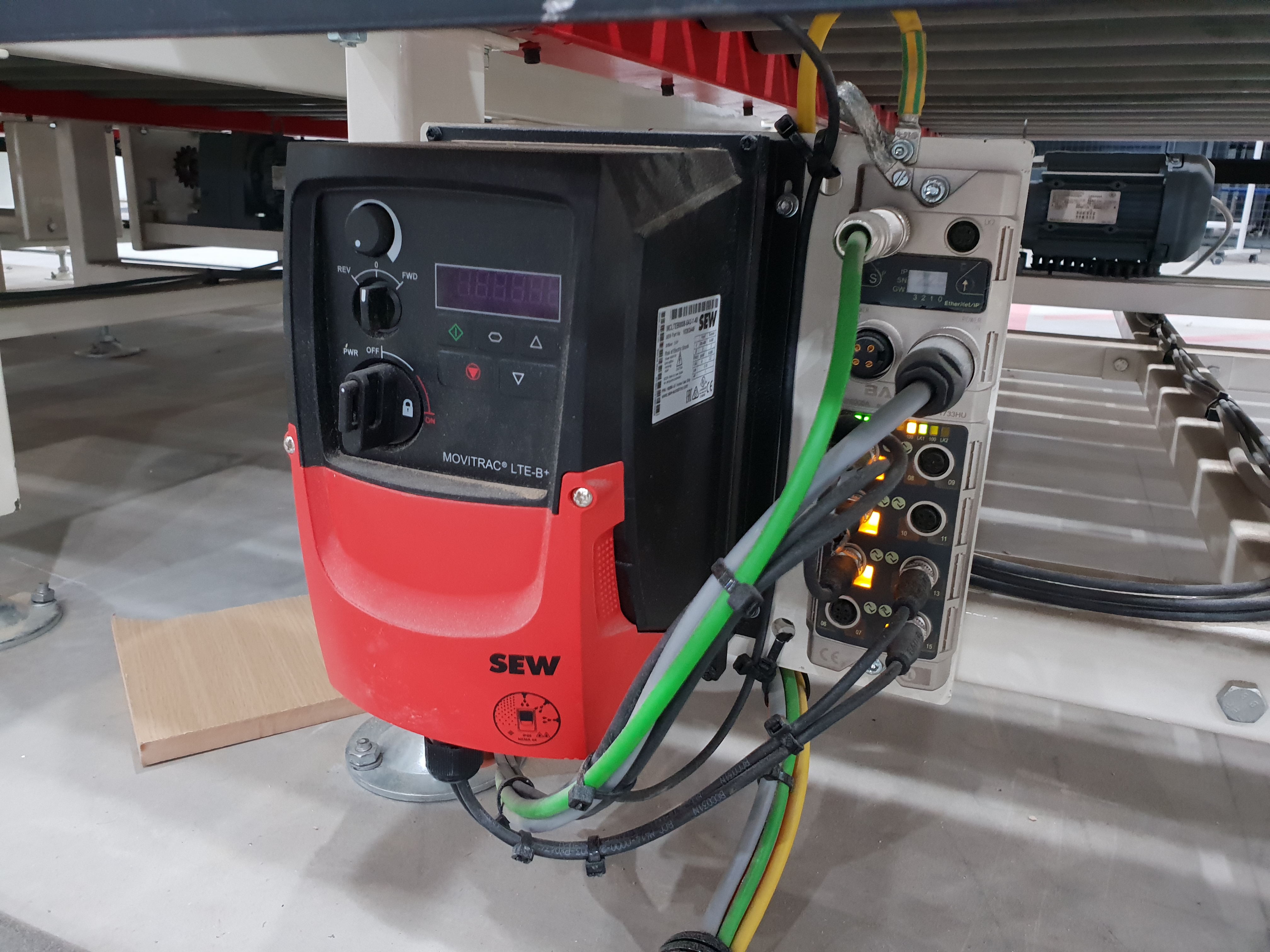 SEW Movitrac LTE-B+ variable frequency drive mounted to a conveyor frame, beside a Murr distributed IO-Link safety and IO block